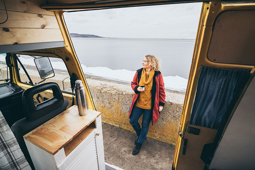 Women drinking a nice warm cup of coffee on the sea wall literally not even a meter away from where she slept the campervan