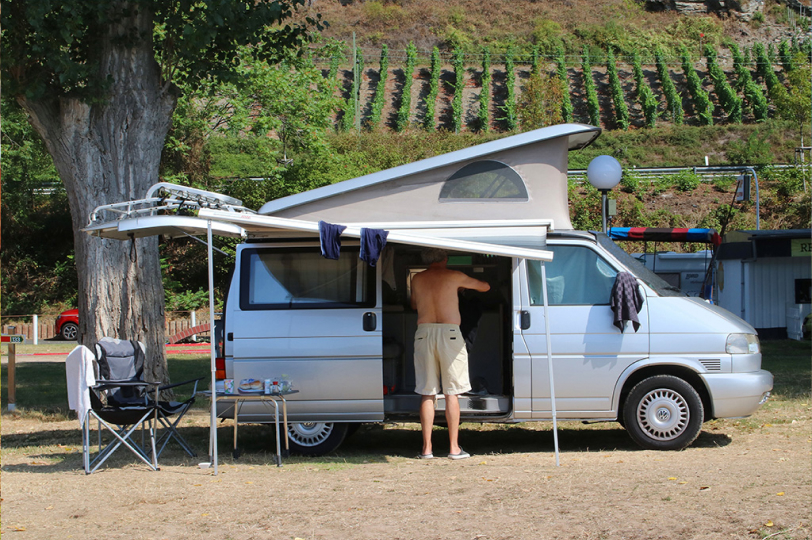 man in a silver van with roof popped