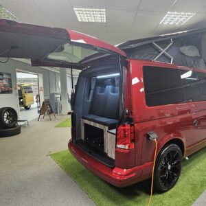 angled shot of a T6.1 Volkswagen Transporter Startline Campervan in Fortana Red with a pop top and the doors open