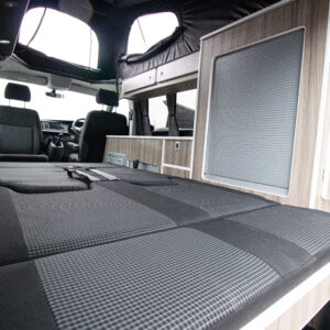 Interior view of the Ice Blue campervan with the rear seats lowered to make the bed