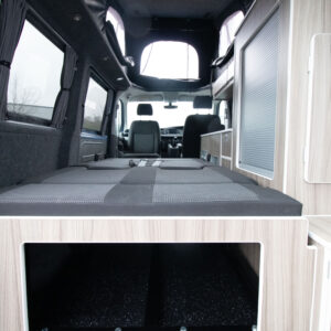 Interior view of the Ice Blue campervan with the rear seats lowered to make the bed