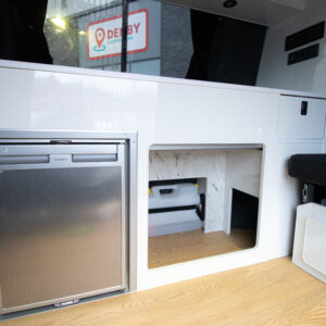 The fridge and storage space in the campervan