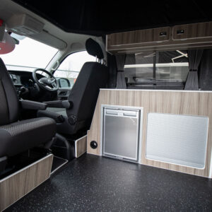 T6.1 Volkswagen Transporter Highline Campervan in Pure Grey with the passenger seat swivelled inward and the fridge and the storage highlighted